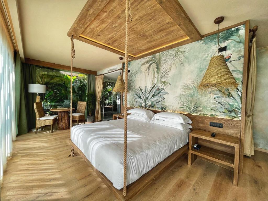 - une chambre avec un lit à baldaquin et du papier peint tropical dans l'établissement AQA Palace, à Caorle