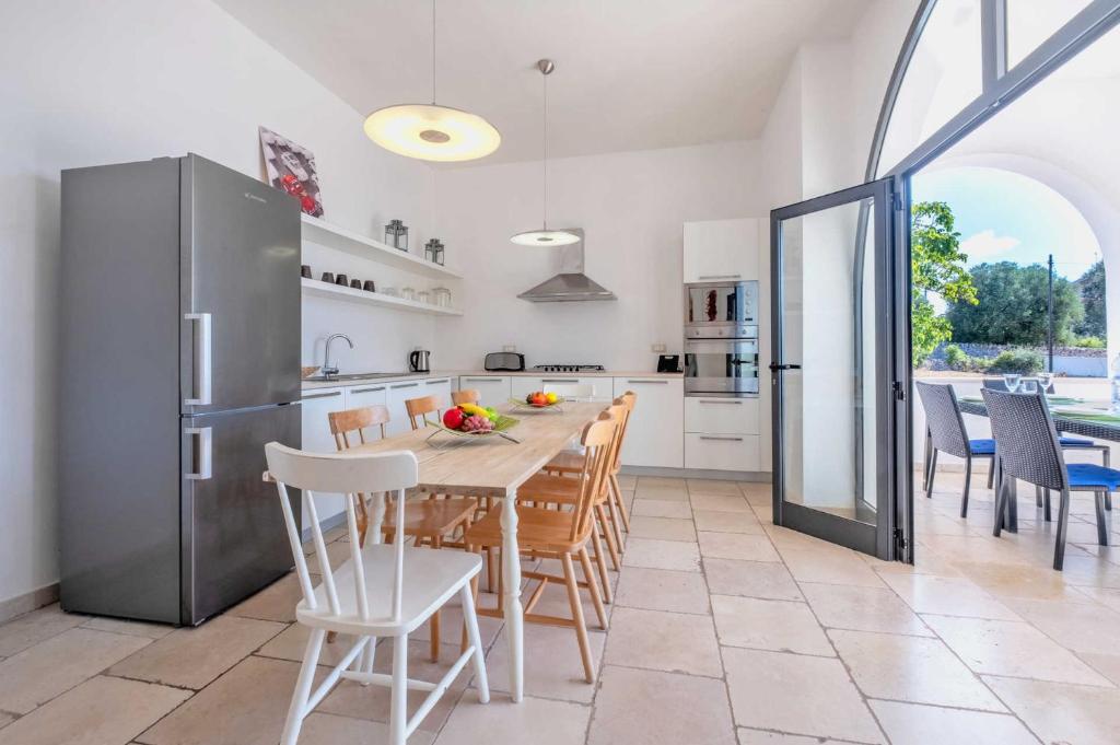 une cuisine et une salle à manger avec une table et des chaises dans l'établissement Villa Azzurrato by Villa Plus, à Ceglie Messapica