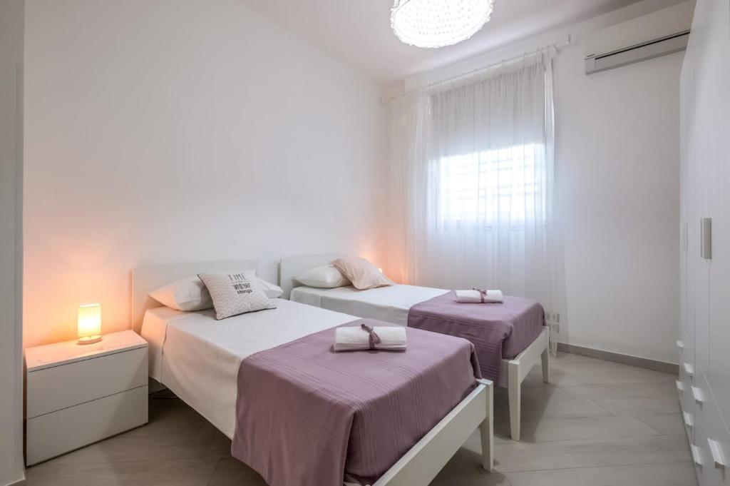 une chambre avec deux lits et une fenêtre dans l'établissement Villa Bella Ostuni by Villa Plus, à Ostuni