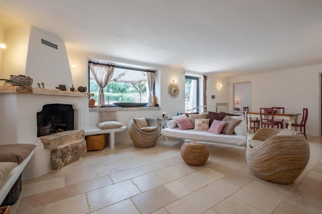 un salon avec un canapé et une cheminée dans l'établissement Villa Trulli Laguna by Villa Plus, à Ostuni