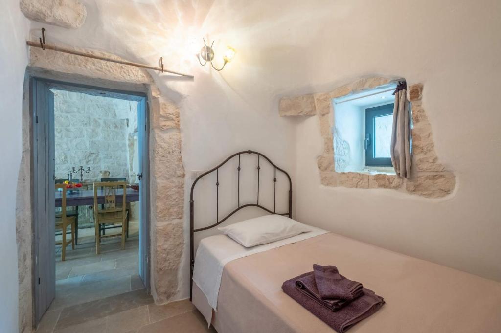 une chambre avec un lit, une table et une fenêtre dans l'établissement Villa Trulli Laguna by Villa Plus, à Ostuni
