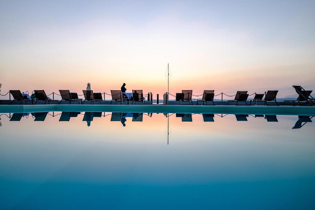 un groupe de chaises assises au bord d'une piscine dans l'établissement AQVA Boutique Hotel (Adults Only), à Sirmione