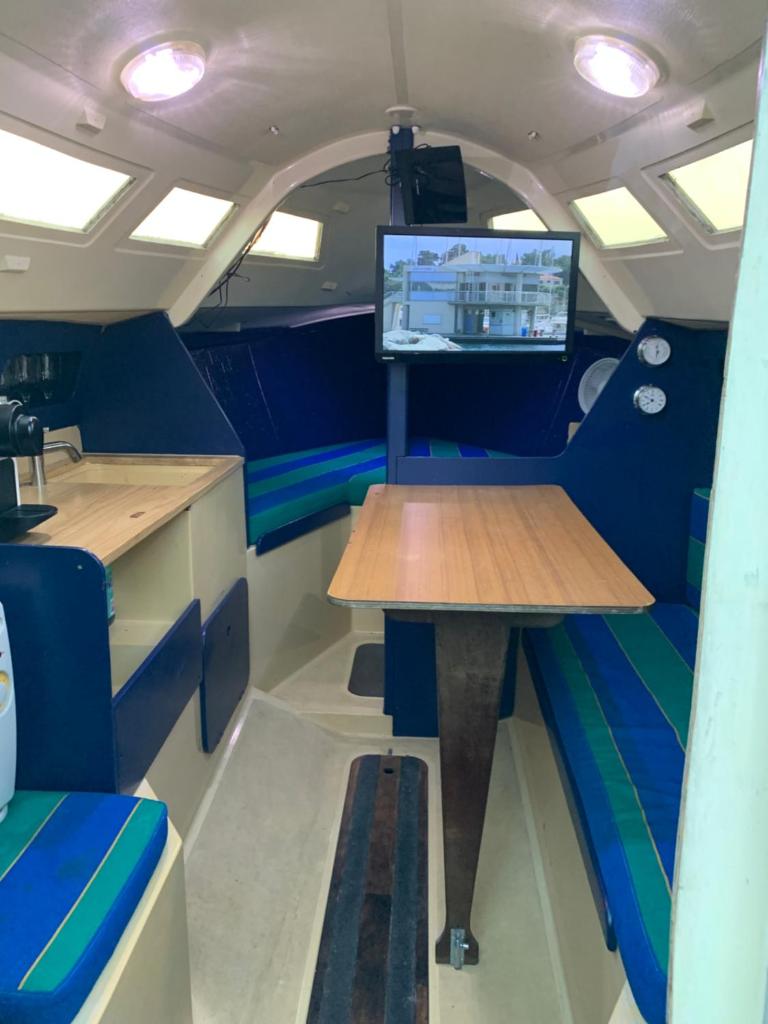 - une table dans un petit bateau avec une télévision dans l'établissement Madi au fil de l'eau à Deauville, à Deauville