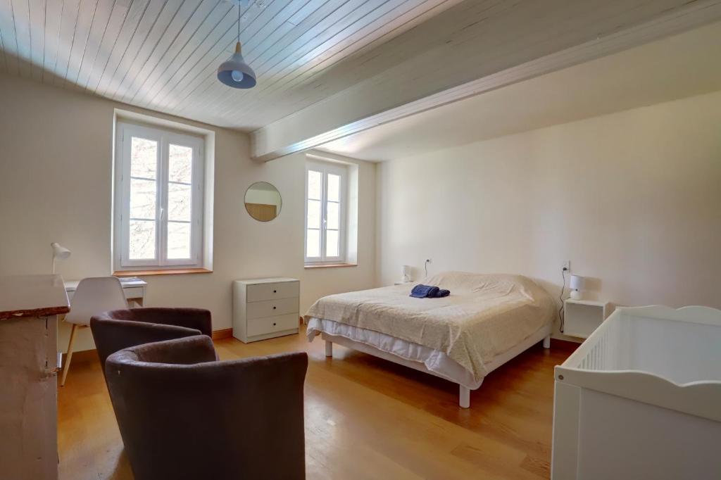 - une chambre avec un lit et des chaises dans l'établissement Gîte la grappe Occitane - 14 personnes - piscine privée, à Ambres