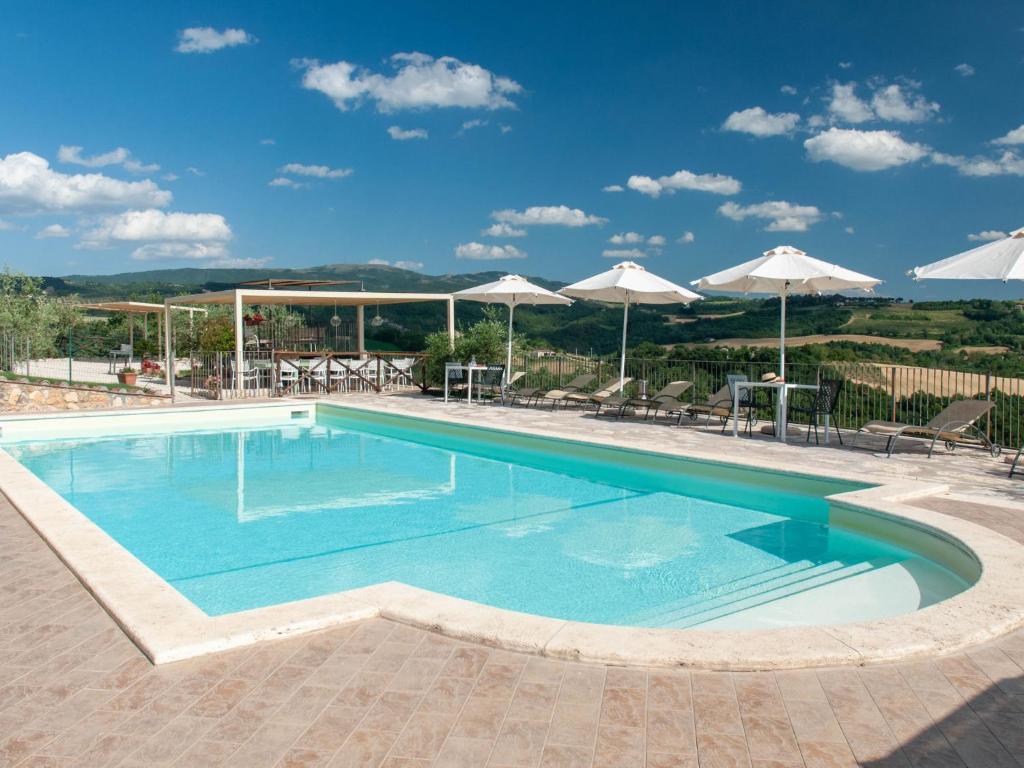 - une piscine avec de l'eau bleue et des parasols blancs dans l'établissement Villa Futura by Interhome, à Lorgnano