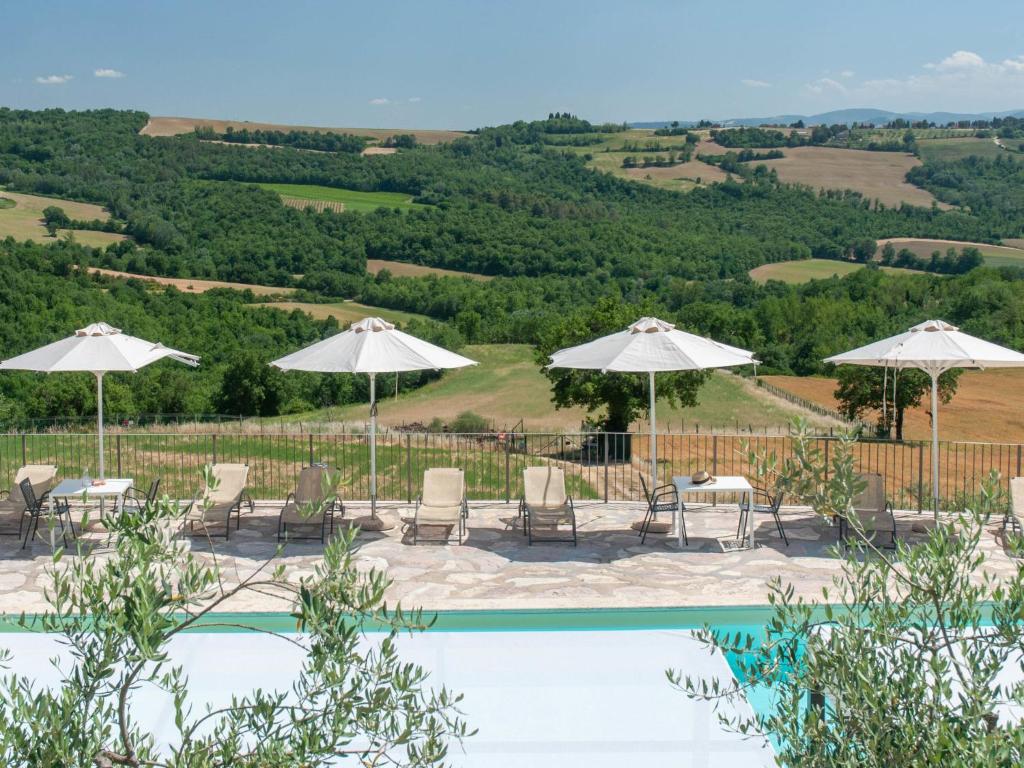 une piscine avec des parasols et des chaises et une vue sur une colline dans l'établissement Villa Futura by Interhome, à Lorgnano