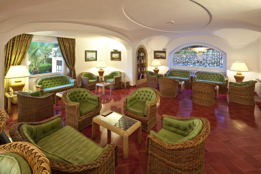 - un salon avec des chaises et des tables vertes dans l'établissement Grand Hotel Il Moresco, à Ischia