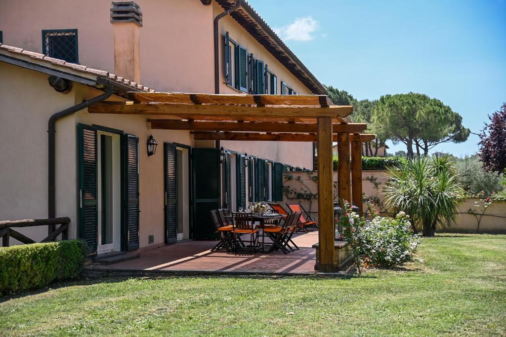 une pergola en bois avec une table et des chaises sur une terrasse dans l'établissement Tenuta Santa Cristina, à Magliano Sabina