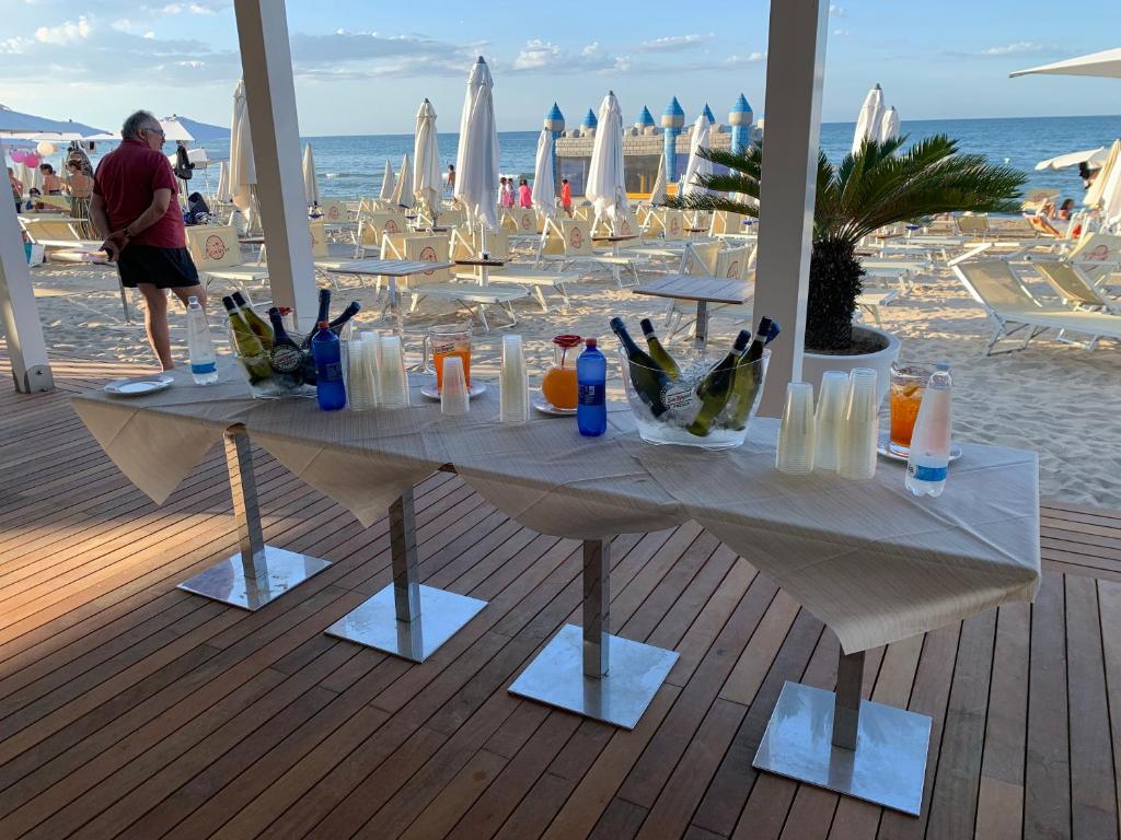 une table sur la plage avec des boissons dessus dans l'établissement Villaggio Benvivere, à Senigallia