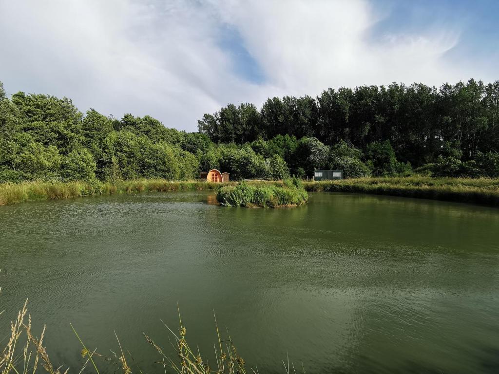 une masse d'eau avec un pont en arrière-plan dans l'établissement Charmant POD en bois près d'un plan d'eau, à Nielles-lès-Ardres