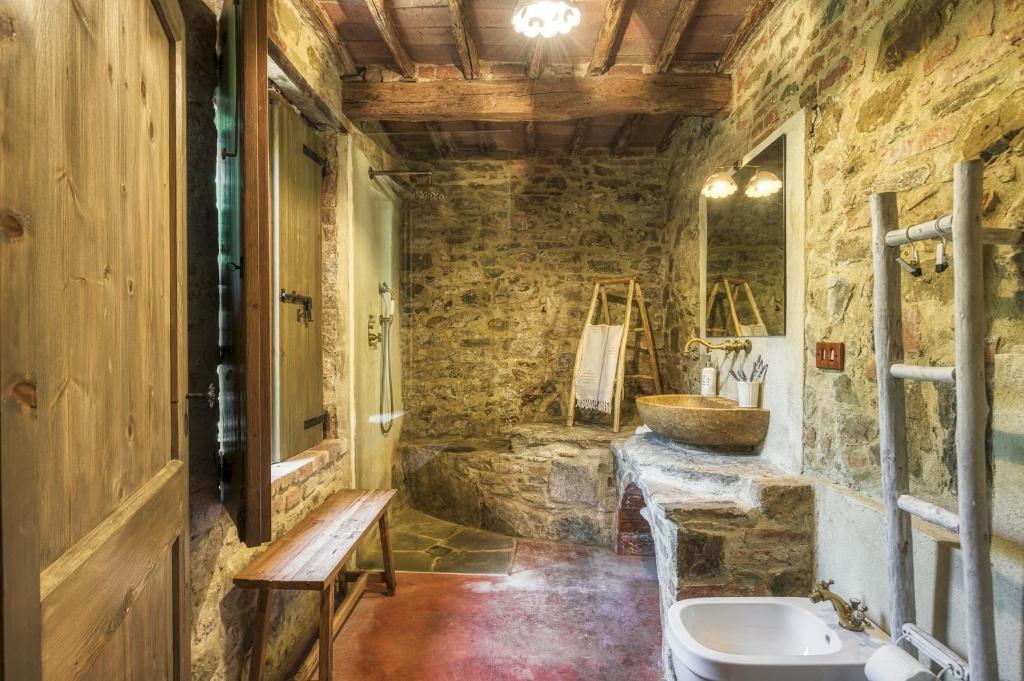 une salle de bain en pierre avec un lavabo et des toilettes dans l'établissement CASA DI PAN 6, Emma Villas, à Panicale