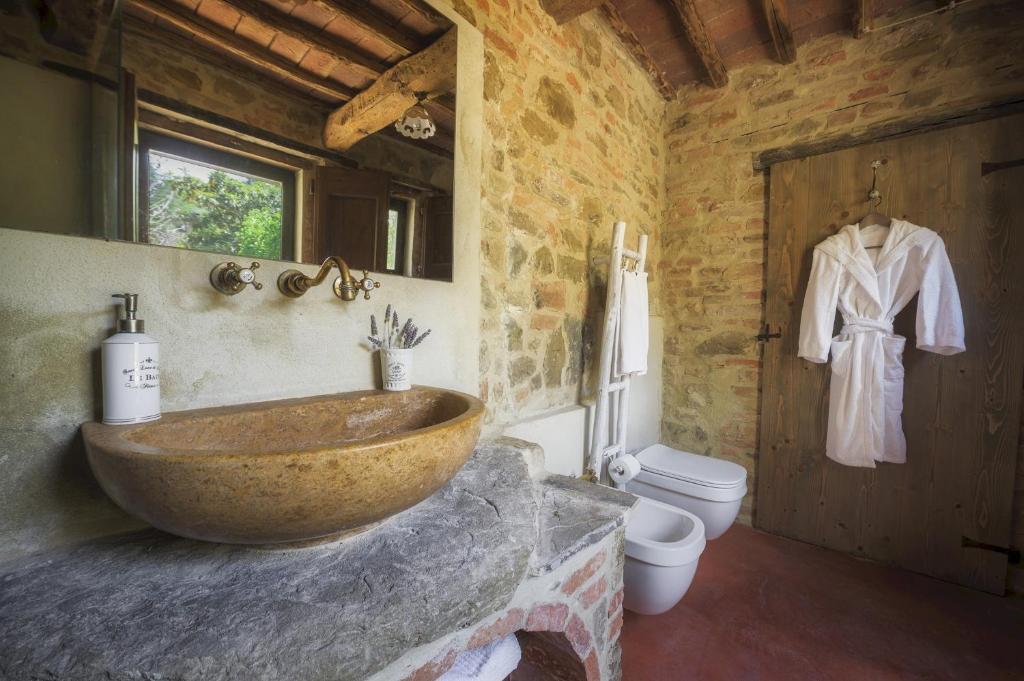 La salle de bains est pourvue d'un grand lavabo en pierre et de toilettes. dans l'établissement CASA DI PAN 6, Emma Villas, à Panicale 31 autres photos