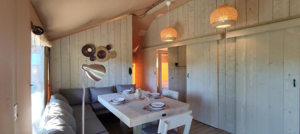 un salon avec une table blanche et un canapé dans l'établissement Tente Hula, à Colleville