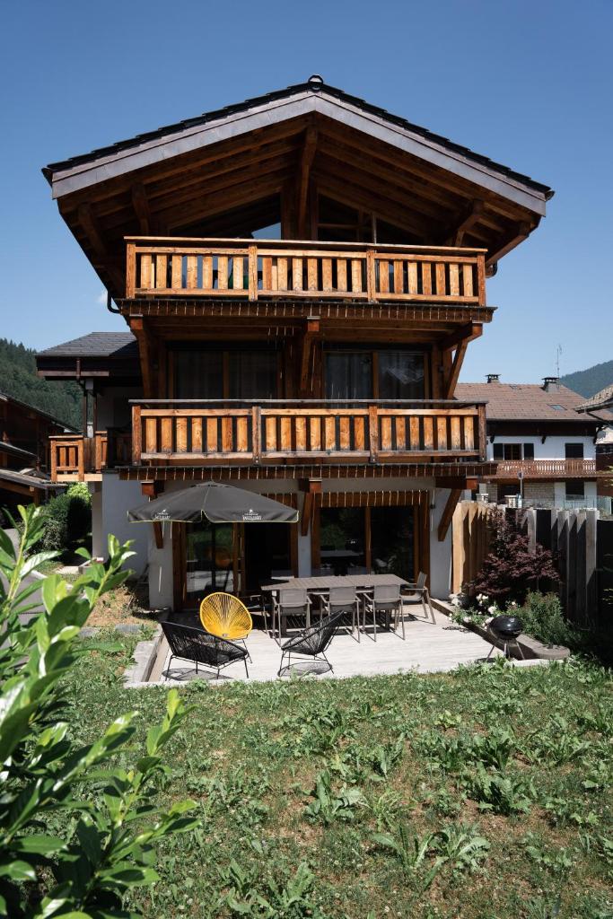une grande maison en bois avec des tables et des chaises dans l'établissement Le Chalet Nativ, à Morzine