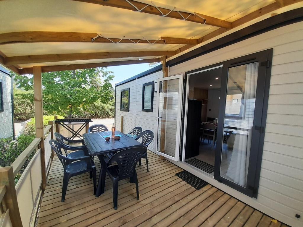 un patio avec une table et des chaises sur une terrasse dans l'établissement Camping Tikayan L'Oxygène, à Valensole 33 autres photos