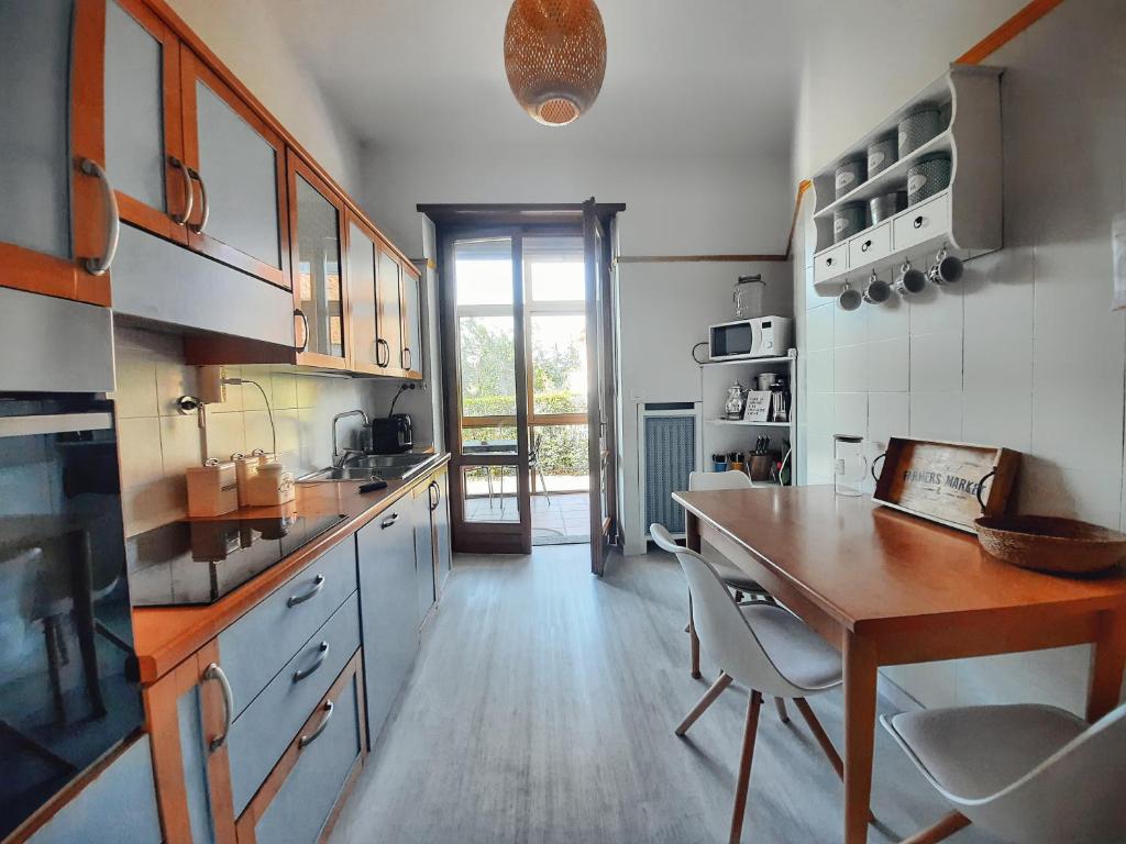 une grande cuisine avec une table et des chaises en bois dans l'établissement Villa Sequoia, à Leinì