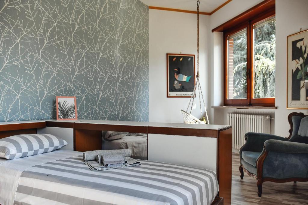 une chambre avec un lit et une chaise dans l'établissement Villa Sequoia, à Leinì 76 autres photos