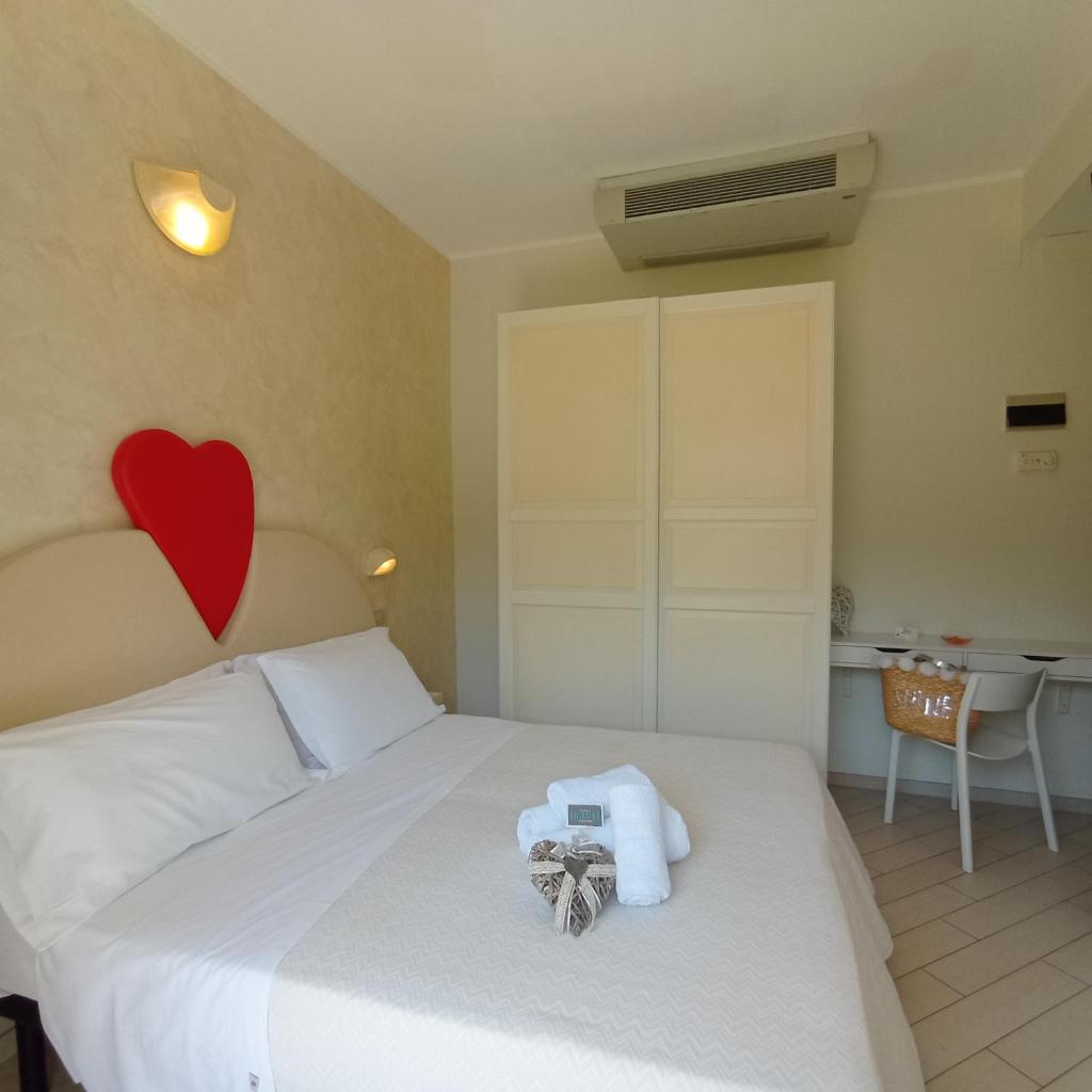 une chambre avec un lit avec un cœur sur le mur dans l'établissement Hotel Raul, à Riccione
