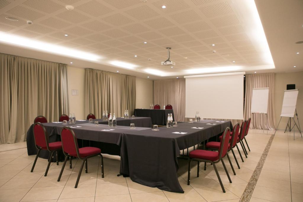 une salle de conférence avec une longue table et des chaises rouges dans l'établissement Splendido Bay Luxury Spa Resort, à Padenghe sul Garda 89 autres photos