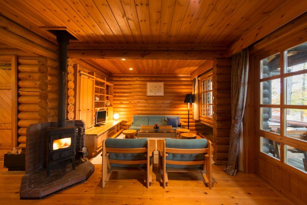 une chambre avec une cheminée dans une cabane en rondins dans l'établissement Hotel Nidom, à Tomakomai