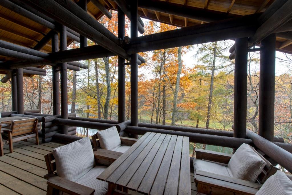 une terrasse couverte en bois avec des chaises et une table en bois dans l'établissement Hotel Nidom, à Tomakomai