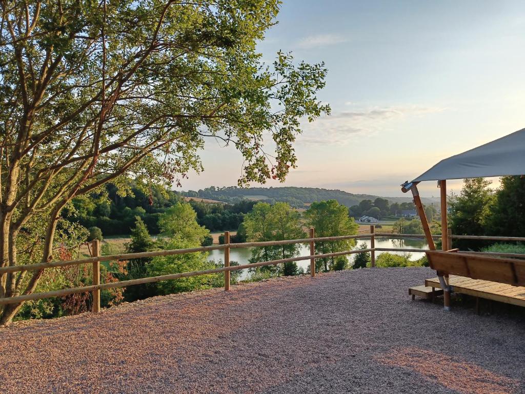 un banc et une clôture avec vue sur la rivière dans l'établissement Tente Sirin, à Colleville