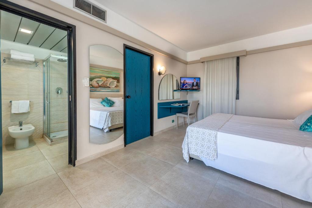 une chambre avec un lit et une salle de bain avec douche dans l'établissement Acacia Marina, à Marina di Ragusa