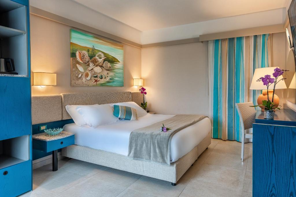 une chambre avec un grand lit blanc dans une pièce dans l'établissement Acacia Marina, à Marina di Ragusa