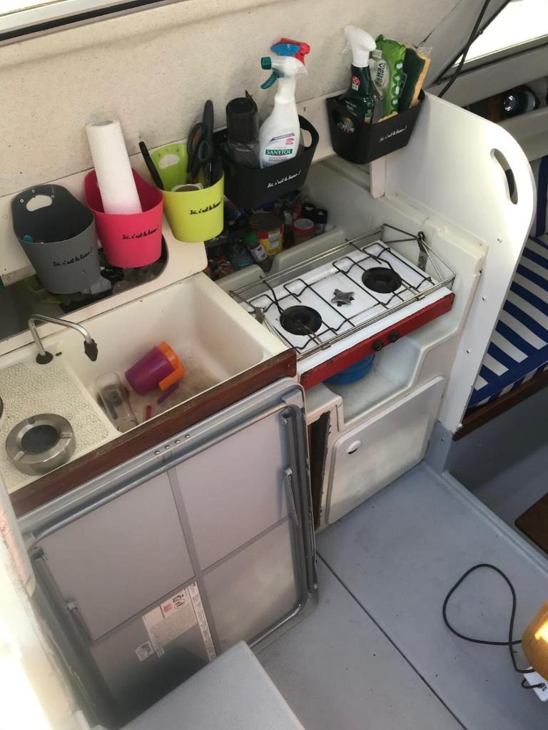 Elle comprend un petit réfrigérateur avec une porte ouverte et une cuisinière. dans l'établissement Havre de Paix, au Havre