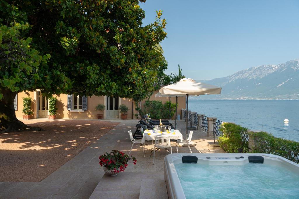 un jacuzzi installé sur une terrasse au bord de l'eau dans l'établissement Villa delle Palme, à Gargnano