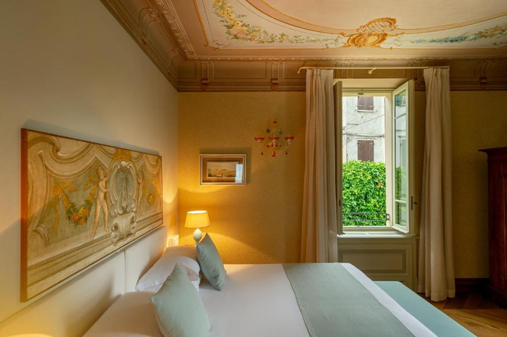 une chambre avec un lit et une fenêtre dans l'établissement Villa delle Palme, à Gargnano