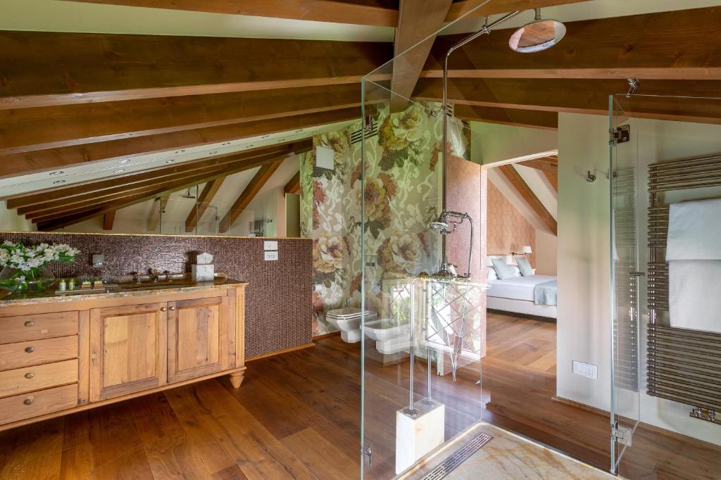 une salle de bain avec une douche en verre dans une chambre dans l'établissement Villa delle Palme, à Gargnano