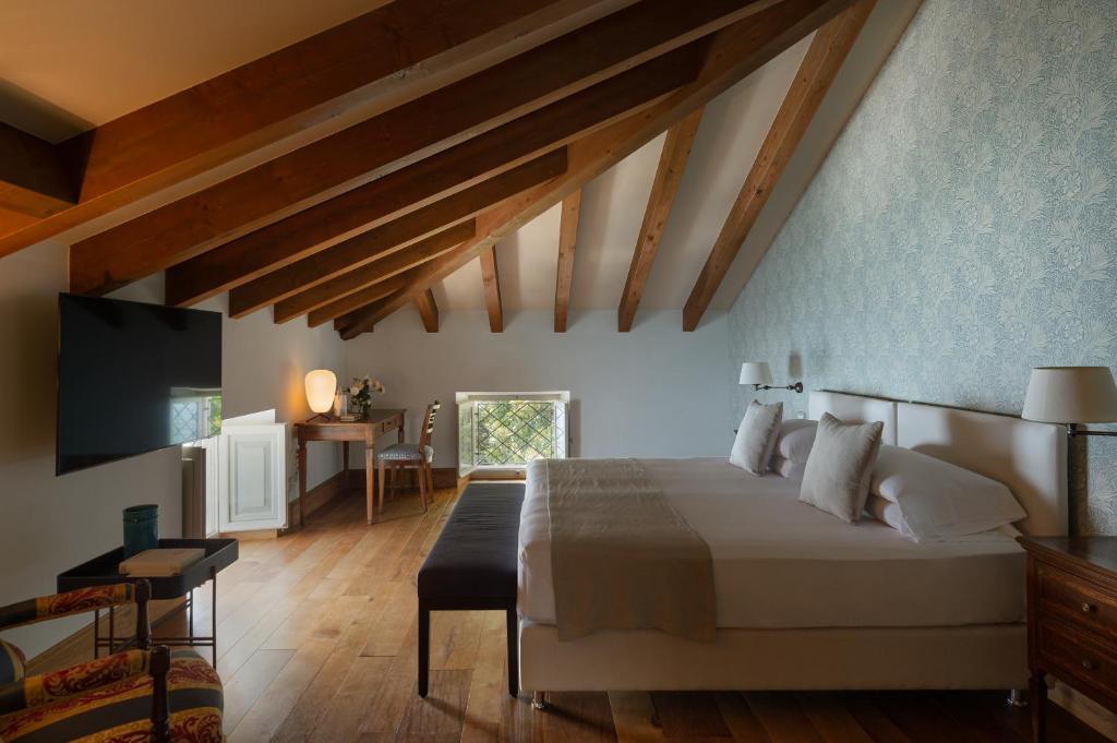 une chambre avec un grand lit et une télévision dans l'établissement Villa delle Palme, à Gargnano