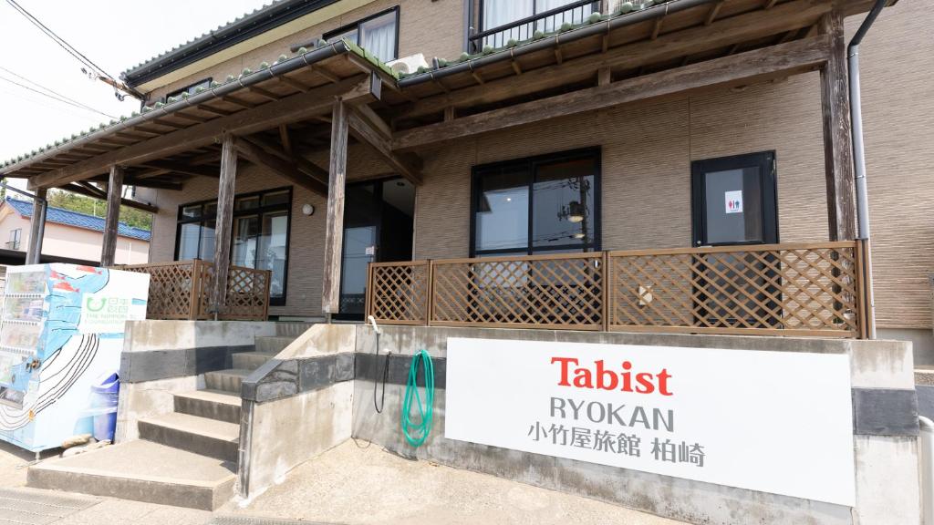 un bâtiment avec une enseigne devant lui dans l'établissement Tabist Odakeya Ryokan Kashiwazaki, à Kashiwazaki