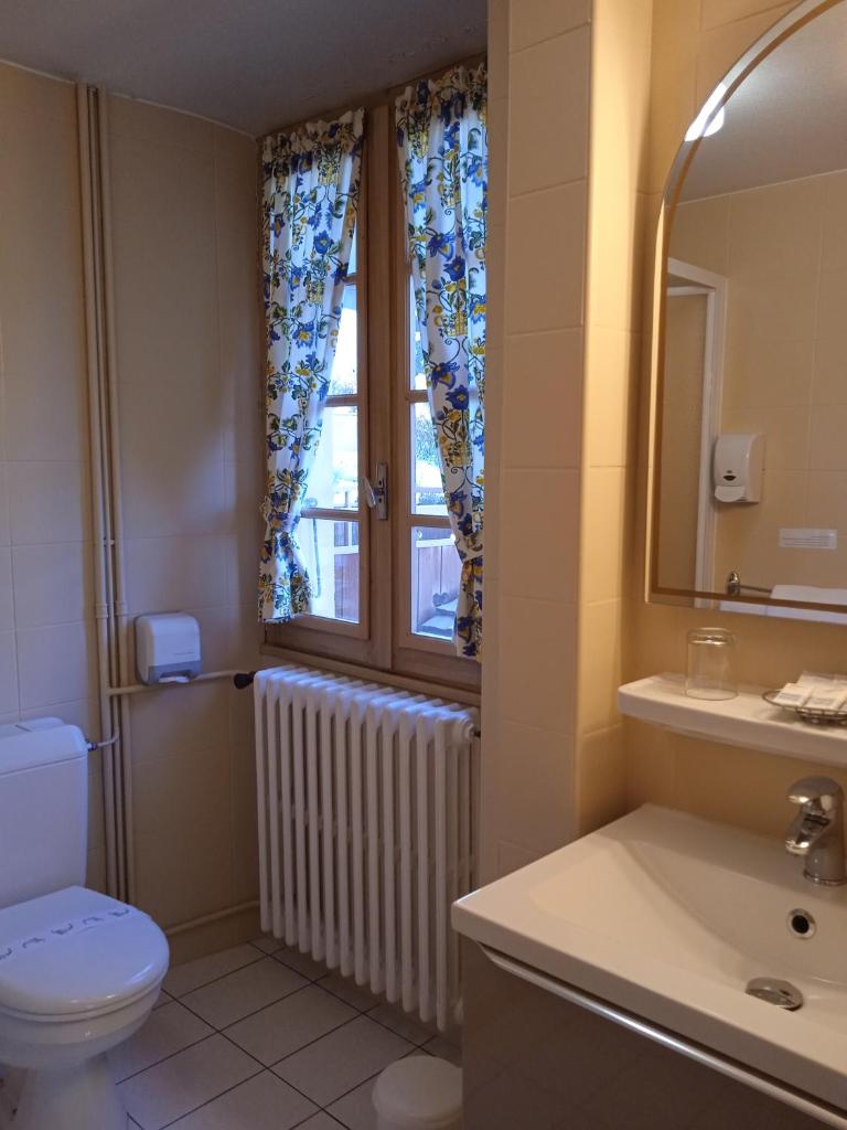 une salle de bain avec toilettes et fenêtre dans l'établissement Hotel les Sapins, à La Clusaz 37 autres photos