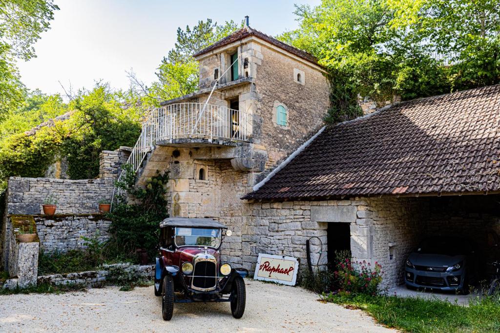 une vieille voiture garée devant un immeuble dans l'établissement Le Domaine des Carriers - Gites, à Chevroches