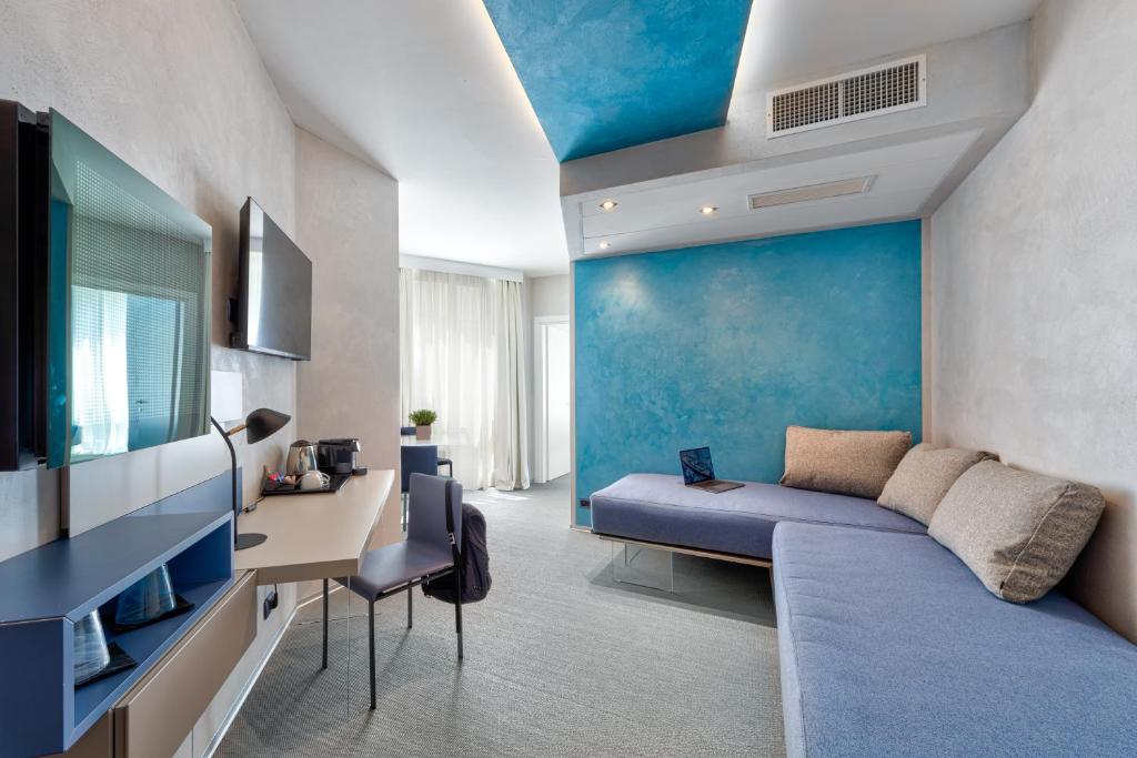 un salon avec un mur bleu et un canapé dans l'établissement Carrick Hotel Camogli Portofino Coast, à Camogli