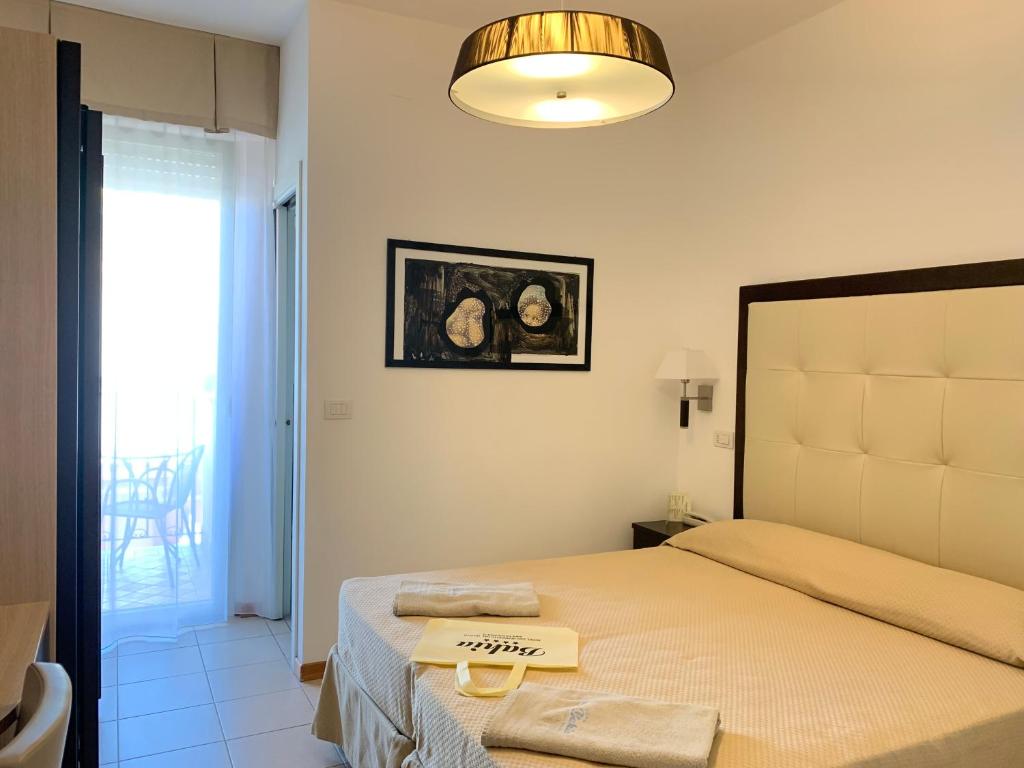 - une chambre avec un lit doté d'une grande tête de lit dans l'établissement Hotel Bahia, à San Benedetto del Tronto