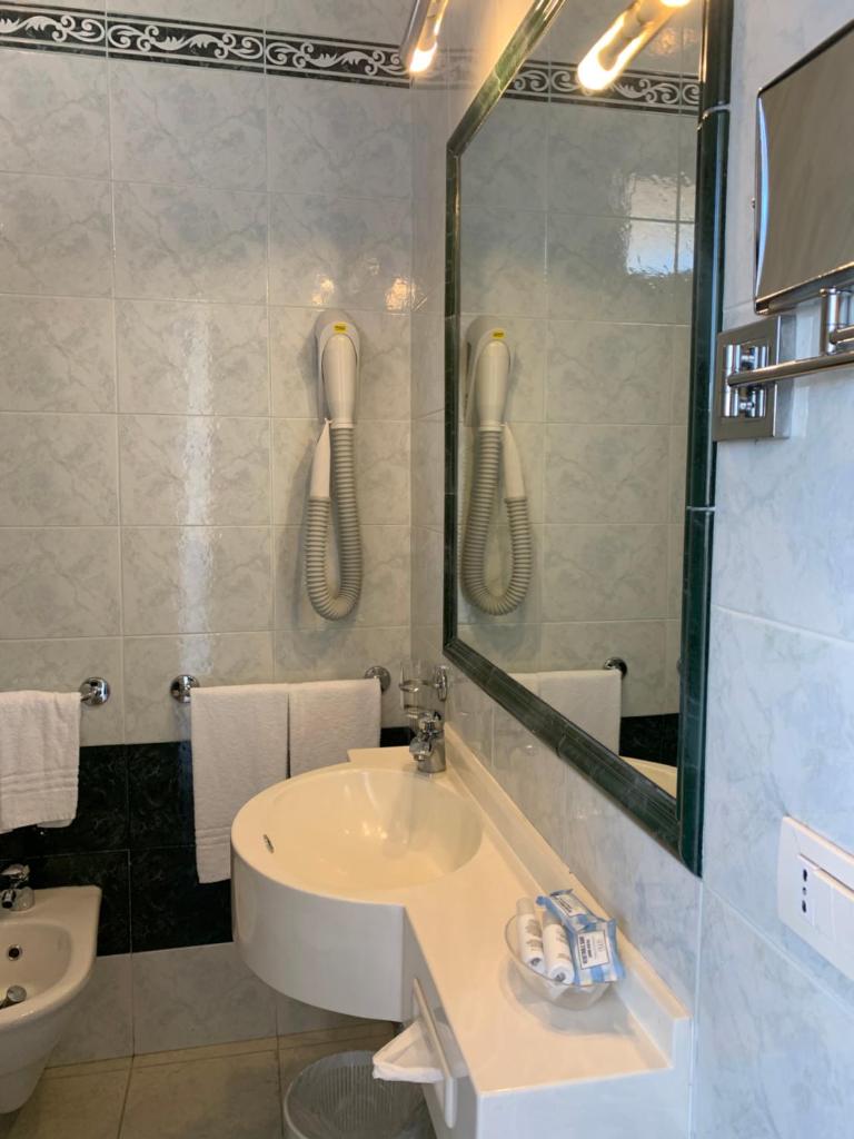 une salle de bain avec un lavabo et un miroir dans l'établissement Hotel Bahia, à San Benedetto del Tronto