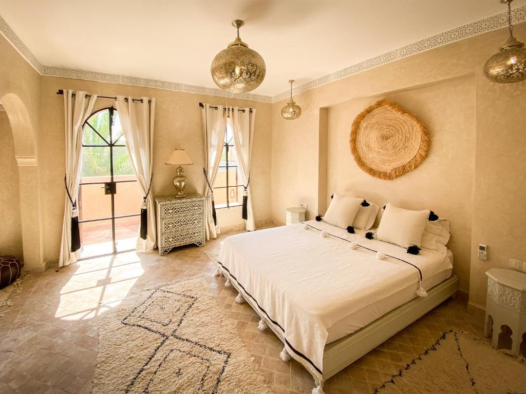 une chambre avec un lit blanc et une grande fenêtre dans l'établissement Riad Selouane, à Marrakech