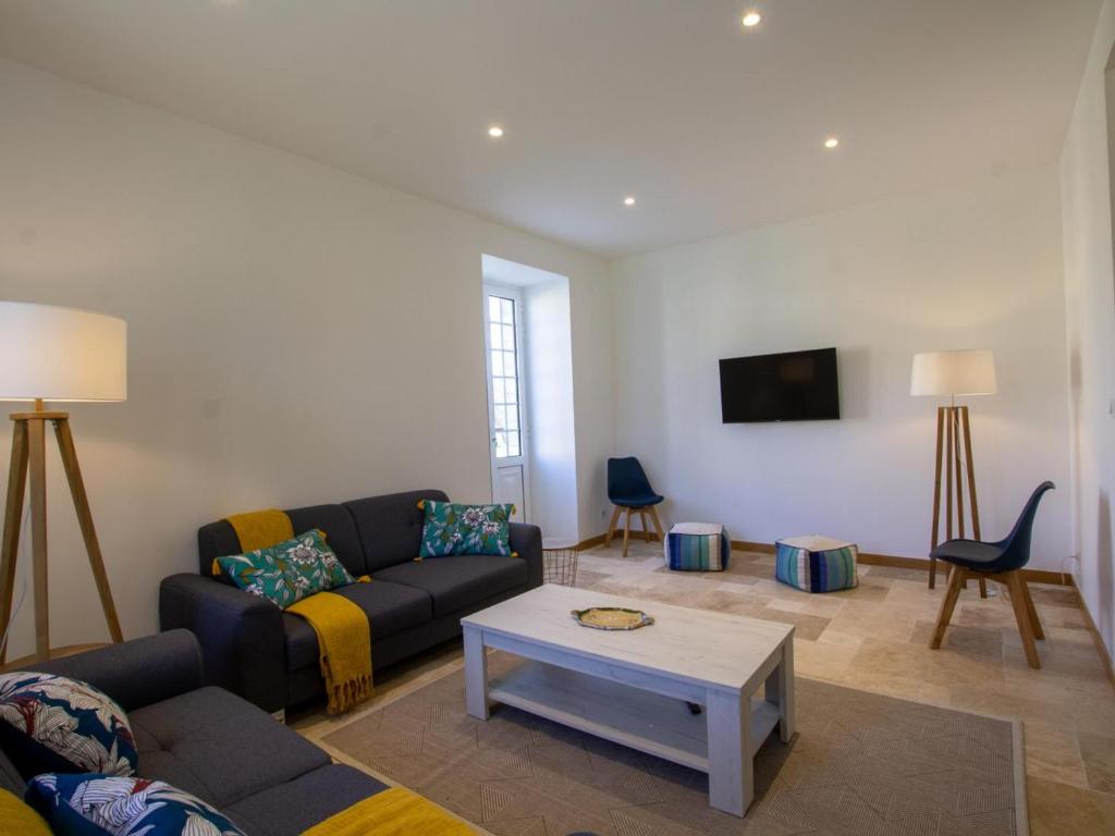 un salon avec un canapé et une table dans l'établissement Grande maison rénovée avec piscine privée et parc, idéale pour vacances en famille en Dordogne - FR-1-616-216, à Savignac-les-Églises
