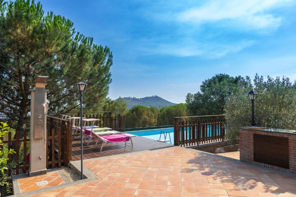 une terrasse en bois avec une piscine et une terrasse. dans l'établissement La dimora del verde con piscina, à Nicolosi