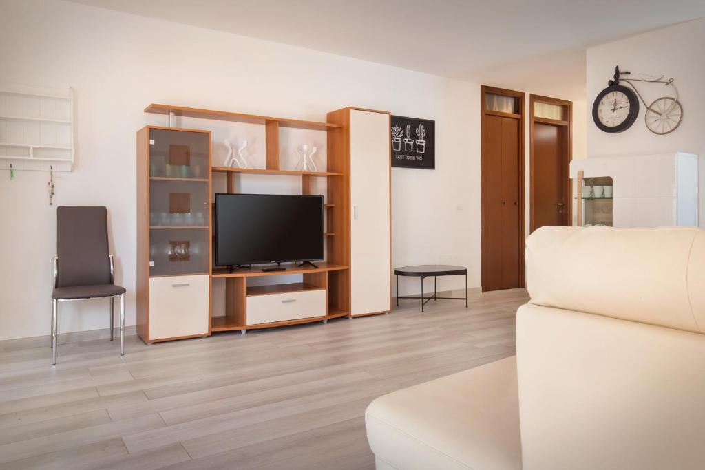 un salon avec une télévision et un canapé dans l'établissement Villa Rose With Pool, à Bardolino