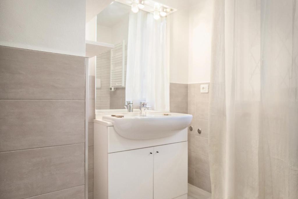 une salle de bain blanche avec un lavabo et une douche dans l'établissement Villa Rose With Pool, à Bardolino