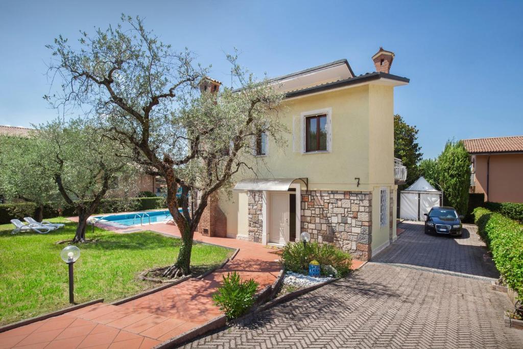 une maison avec une allée et une piscine dans l'établissement Villa Rose With Pool, à Bardolino