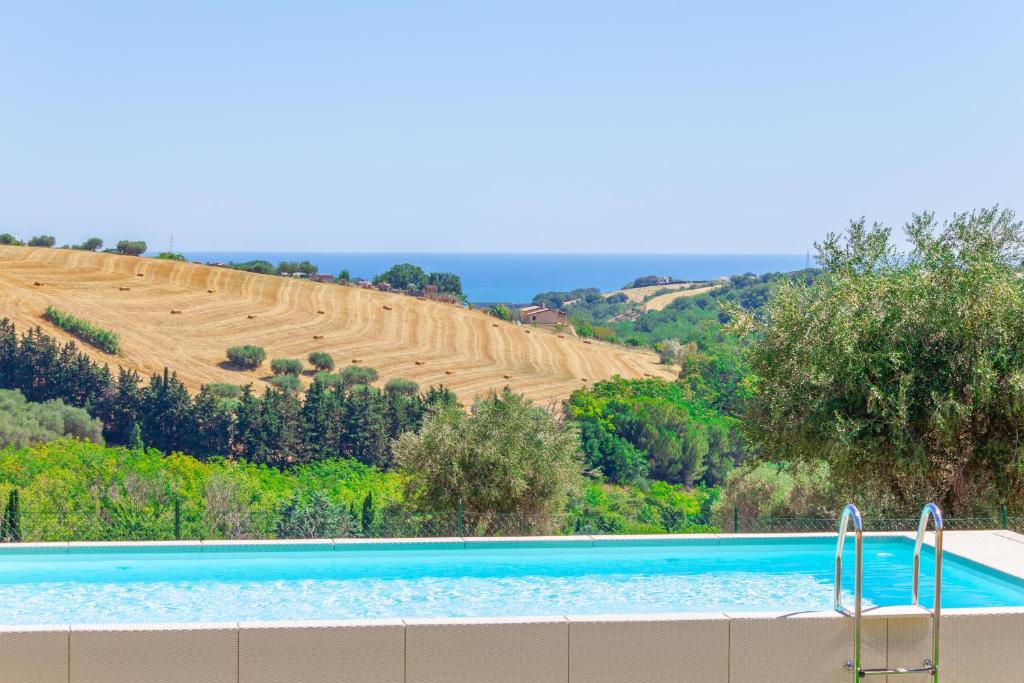 - une piscine en face d'une colline avec un champ dans l'établissement Villa Dell'Arco - Sea View, Private Pool & AirCo, à SantʼElpidio a Mare