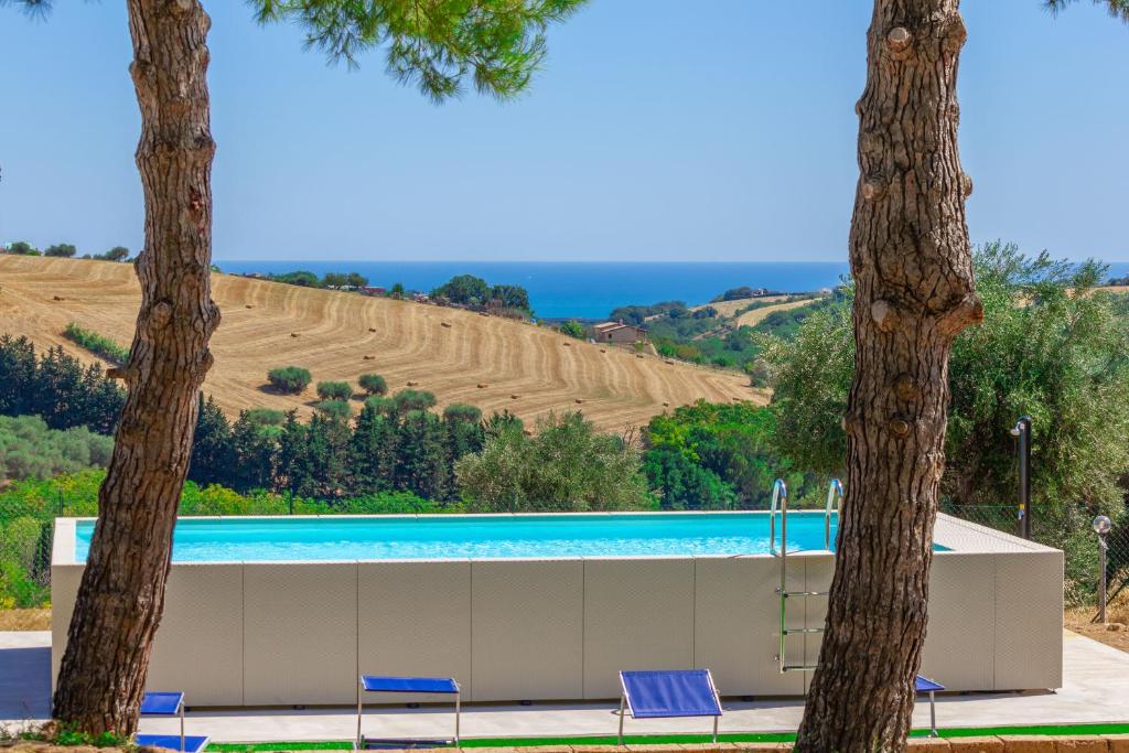 - une piscine avec vue sur les collines et les arbres dans l'établissement Villa Dell'Arco - Sea View, Private Pool & AirCo, à SantʼElpidio a Mare