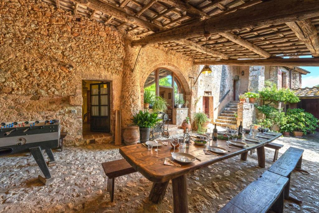 une grande chambre avec une table en bois dans un bâtiment dans l'établissement Podere Lorena, à Monteriggioni