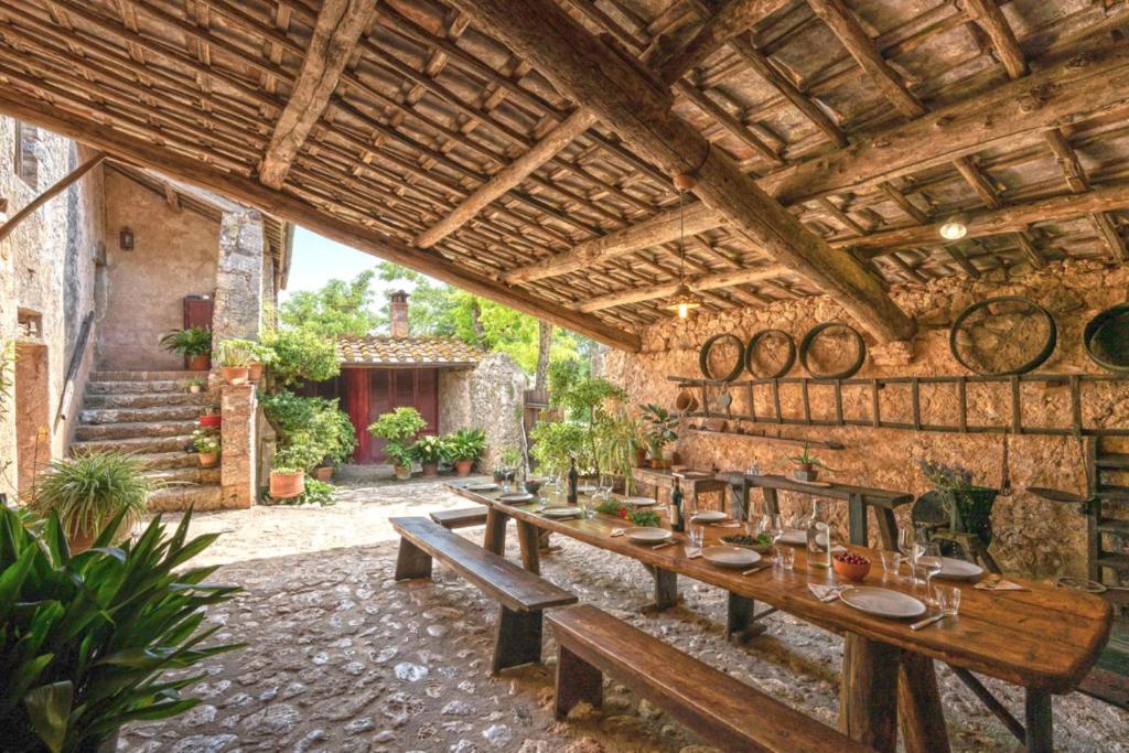 - une terrasse avec une longue table en bois dans un bâtiment dans l'établissement Podere Lorena, à Monteriggioni