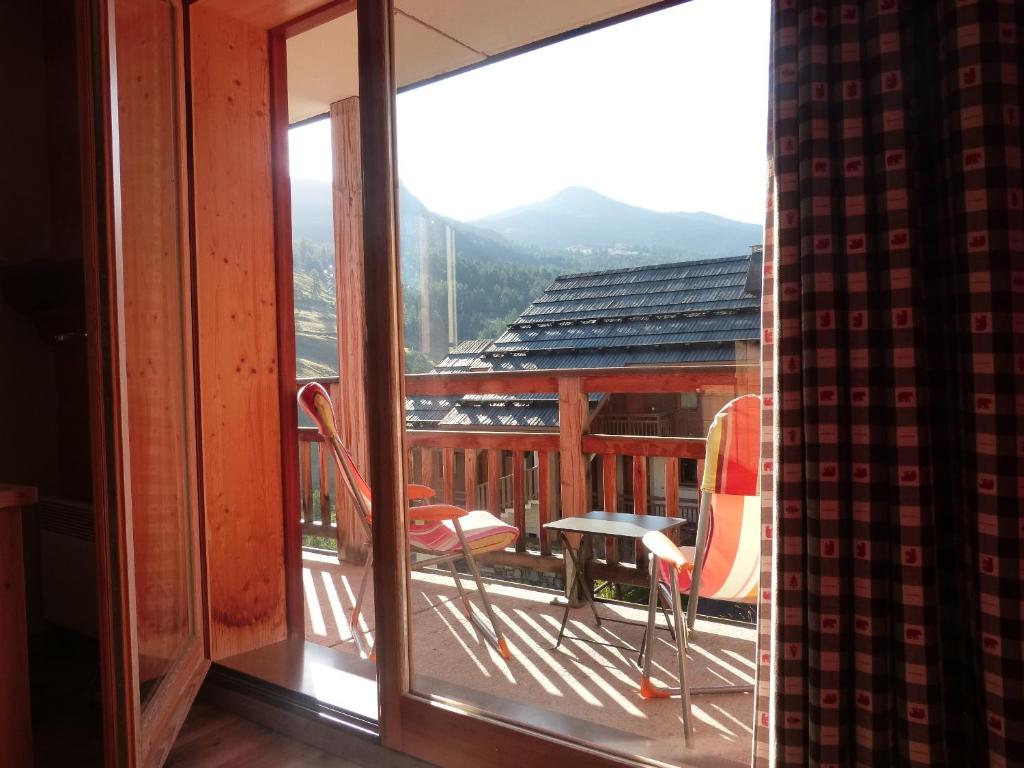 une vue d'un balcon avec des chaises et une table dans l'établissement residence avec piscine ,chalet des rennes, à Vars 4 autres photos